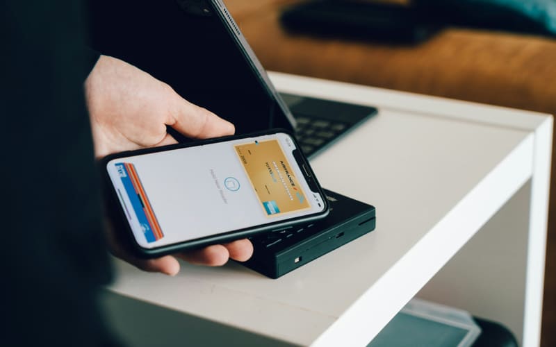 Smartphone wird kontaktlos an ein Kartenterminal gehalten