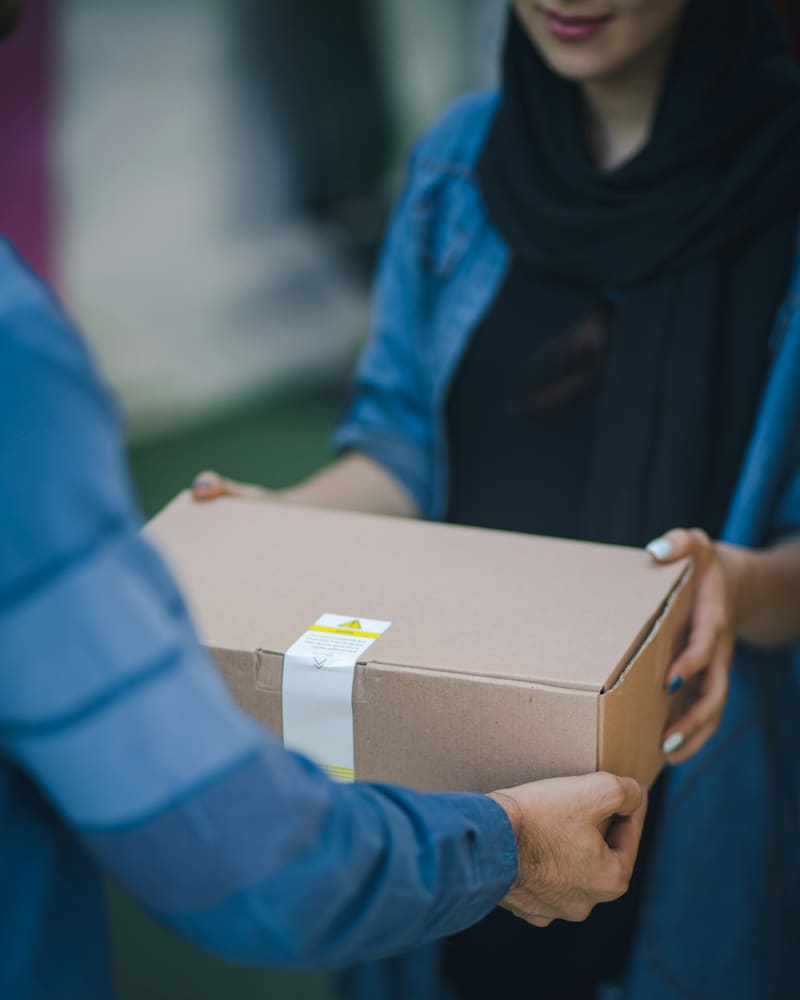 Zusteller übergibt ein Paket an der Haustür